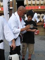 子供に爆竹の付け方を教えているお父さん。